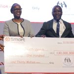 Smart Applications team (Marry Ann Musangi- Board Director (2nd Left, Mr. Harrison Muiru-Group Managing Director (Extreme Right) and Ms. Judy Mugoya- Country Manager-Uganda (Extreme Left) handing over a cheque to Mr. Fredrick Makaire- SHU Executive Director (2nd right)